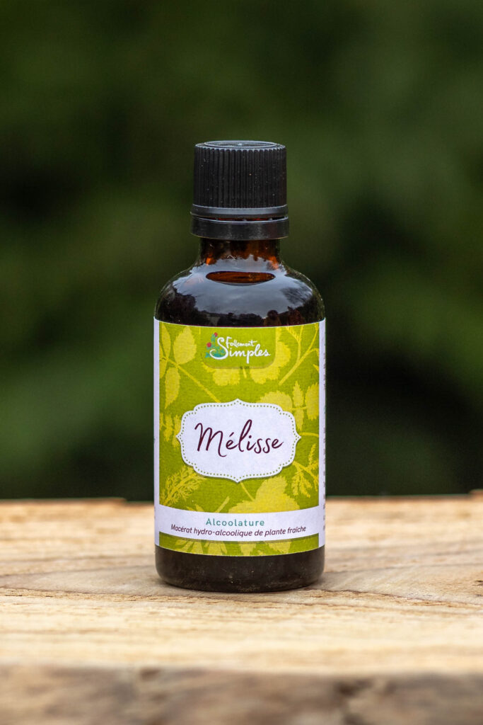 Un flacon d'alcoolature de mélisse posé sur une planche en bois